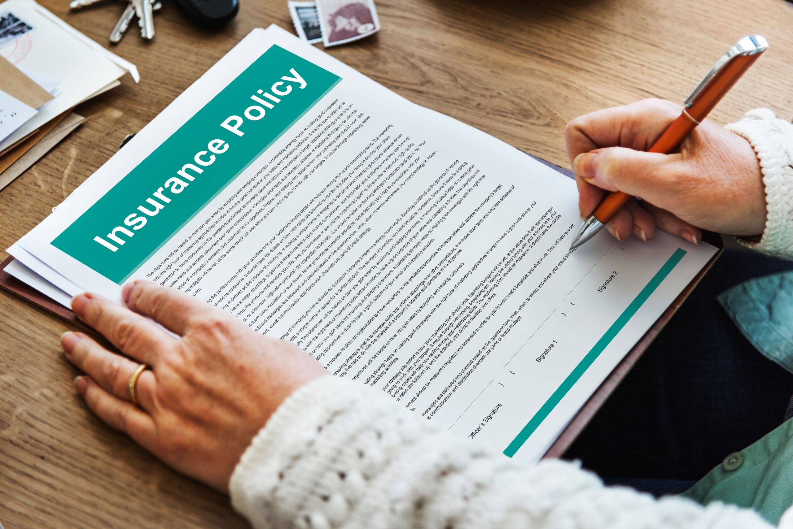 Person signing an insurance policy document – important step in Local vs. Long-Distance Moving process