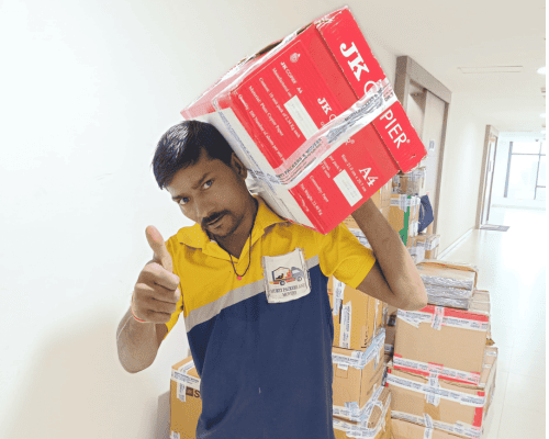 Professional worker from Murti Packers and Movers in Noida carrying packed cartons during safe household shifting service in Noida.