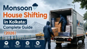 Professional movers loading waterproof packed household goods into a moving truck during monsoon house shifting in Kolkata, showcasing safe relocation practices and rain protection.